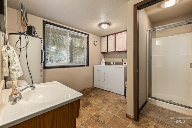 full bathroom with independent washer and dryer, a shower stall, a sink, and electric water heater