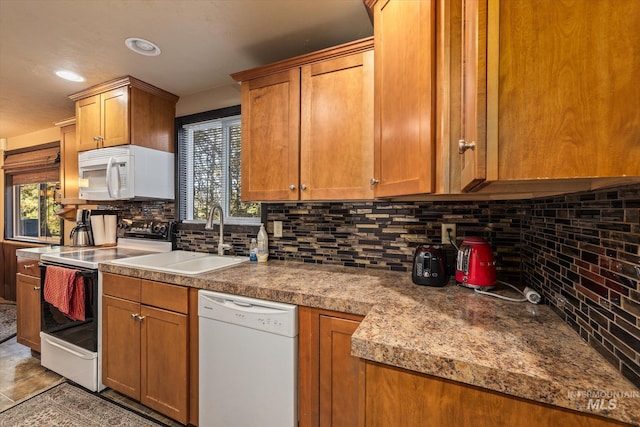 kitchen featuring white appliances, recessed lighting, brown cabinets, tasteful backsplash, and a sink
