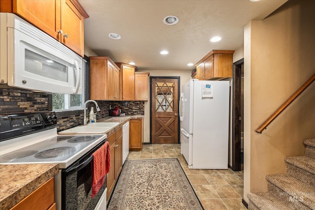 kitchen featuring stone finish flooring, tasteful backsplash, a sink, recessed lighting, and white appliances