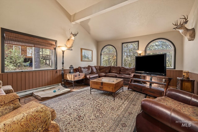 living area with wainscoting, wood finished floors, a baseboard radiator, lofted ceiling with beams, and wooden walls