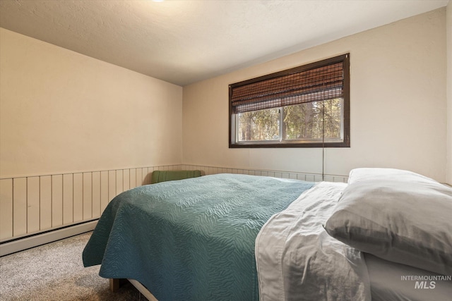 bedroom featuring baseboard heating and carpet flooring