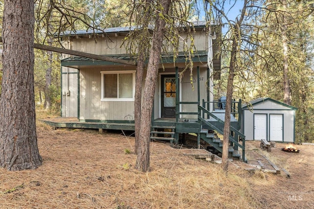 view of front of property featuring a storage shed, metal roof, an outdoor structure, and a porch