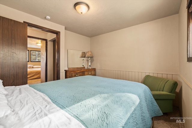bedroom featuring a wainscoted wall