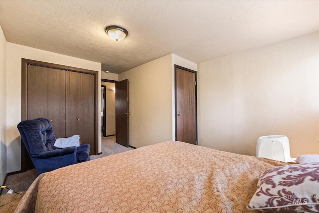 carpeted bedroom featuring a textured ceiling and multiple closets