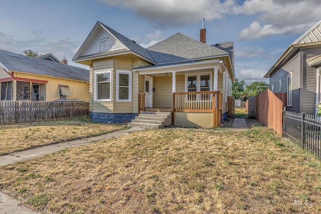 36 W Liberty, Weiser, ID 83672 - view of front of property featuring a porch, roof with shingles, a fenced backyard, and a chimney