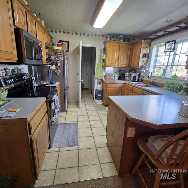 1280 Monroe Creek Rd, Weiser, ID 83672 - kitchen with appliances with stainless steel finishes, a sink, a peninsula, light tile patterned floors, and light countertops