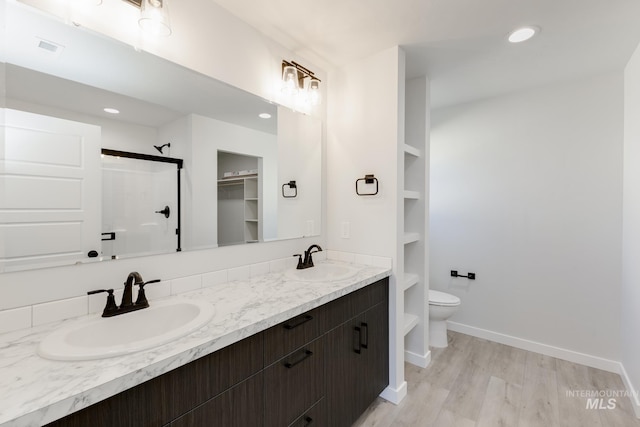 5303 E Grizzly St, Nampa, ID 83687 - full bath with a shower stall, toilet, double vanity, recessed lighting, and wood finished floors