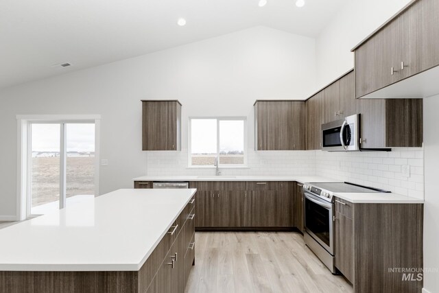5303 E Grizzly St, Nampa, ID 83687 - kitchen featuring appliances with stainless steel finishes, light countertops, healthy amount of natural light, tasteful backsplash, and high vaulted ceiling