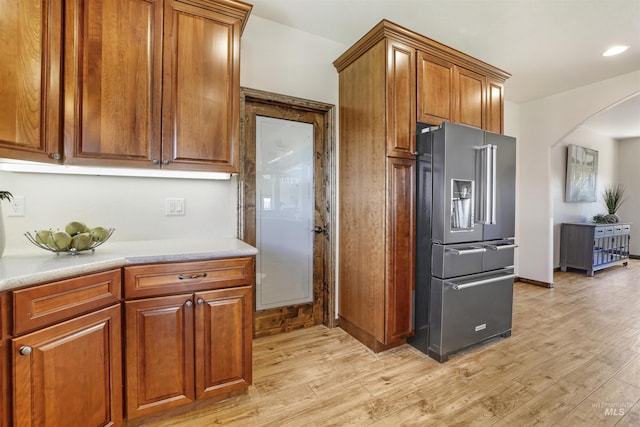kitchen featuring high end refrigerator and light hardwood / wood-style floors