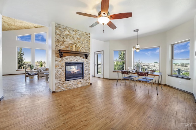 living room featuring ceiling fan, lofted ceiling, hardwood / wood-style floors, and a fireplace