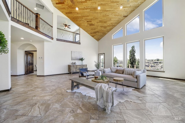 living room featuring ceiling fan, a high ceiling, and wooden ceiling