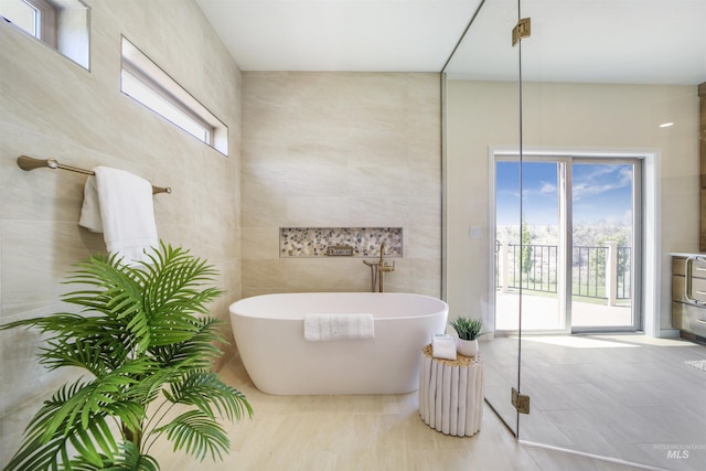 bathroom featuring tile walls and a tub