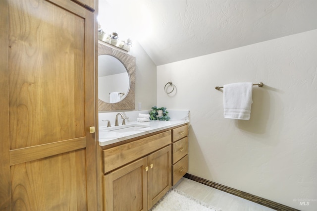 bathroom with vanity and lofted ceiling