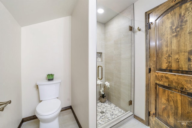 bathroom with an enclosed shower and toilet