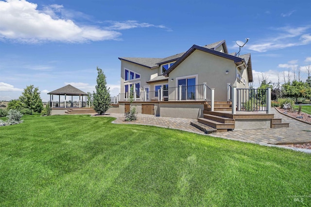 back of property with a yard and a gazebo