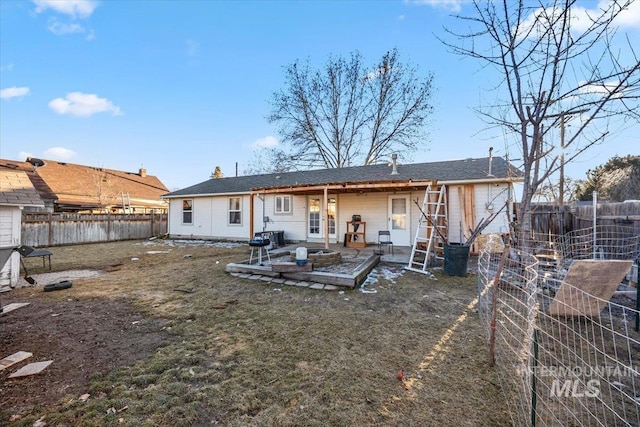 rear view of house featuring a patio, a lawn, and a fenced backyard