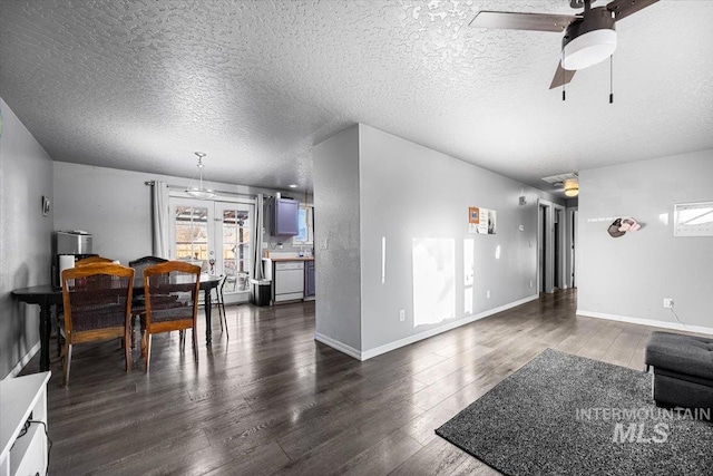 living area with a textured ceiling, dark wood-style flooring, a ceiling fan, and baseboards