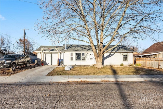 ranch-style home with driveway, an attached garage, and fence