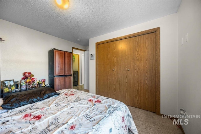 bedroom featuring carpet floors, a textured ceiling, and a closet