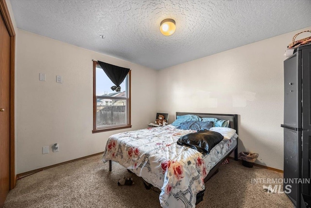 carpeted bedroom with a textured ceiling and baseboards