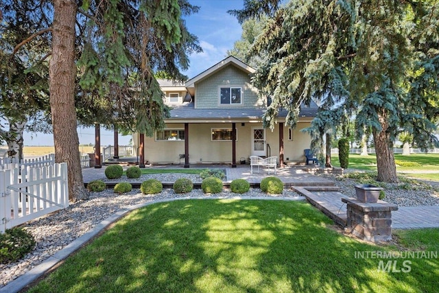farmhouse inspired home with a patio, fence, stucco siding, and a front yard