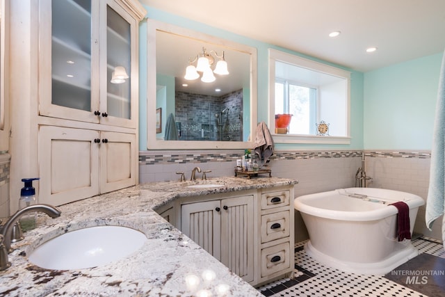 full bath featuring a sink, a shower stall, double vanity, and a freestanding bath