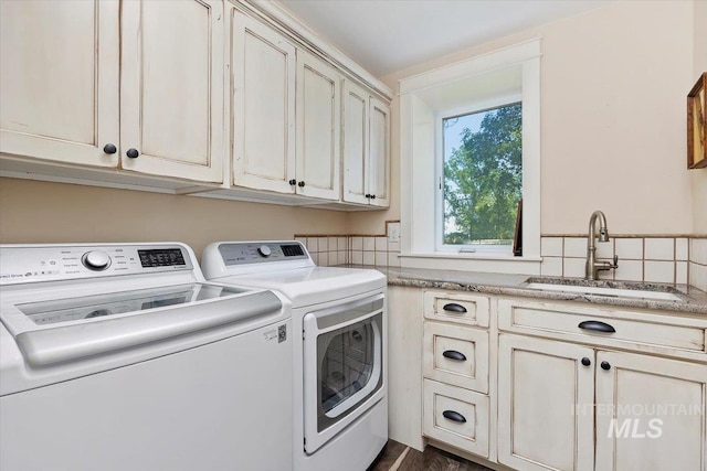 washroom featuring a sink, cabinet space, and washer and dryer