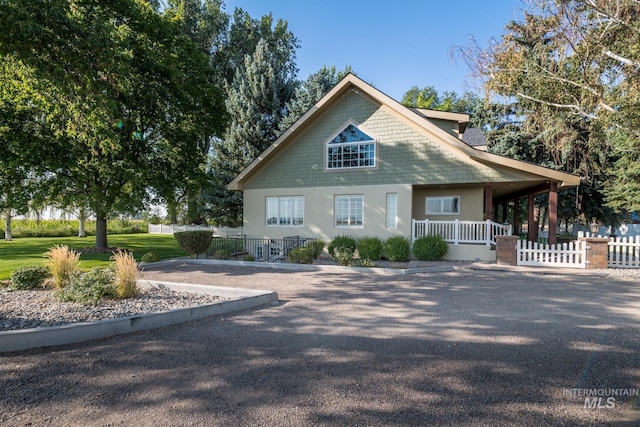 chalet / cabin with fence, stucco siding, and a porch
