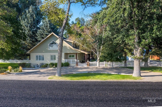 view of front facade with fence private yard and covered porch