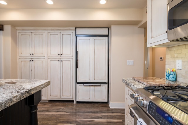 kitchen featuring stainless steel appliances, light stone countertops, recessed lighting, and dark wood-style floors