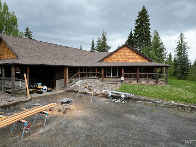 14797 Grangemont Rd, Orofino, ID 83544 - view of front facade featuring a shingled roof, a front yard, and covered porch