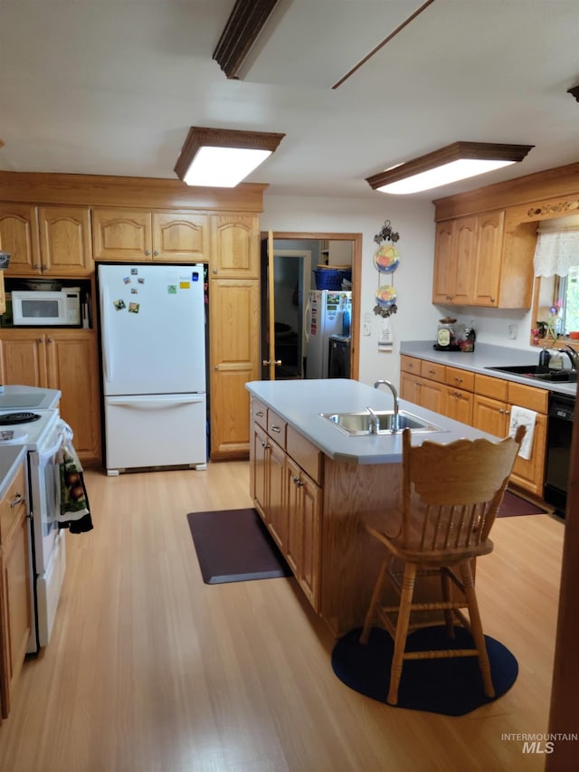 14797 Grangemont Rd, Orofino, ID 83544 - kitchen featuring white appliances, a sink, light wood-style floors, and a kitchen island with sink