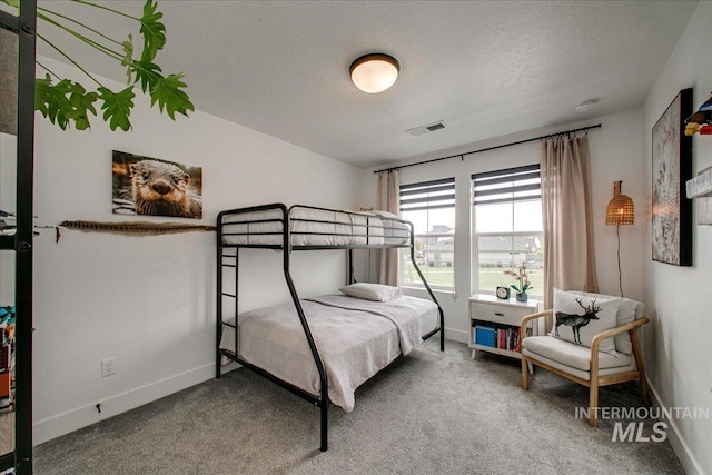 carpeted bedroom featuring baseboards and a textured ceiling