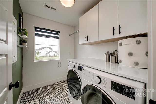 laundry room with cabinet space, separate washer and dryer, baseboards, and tile patterned floors