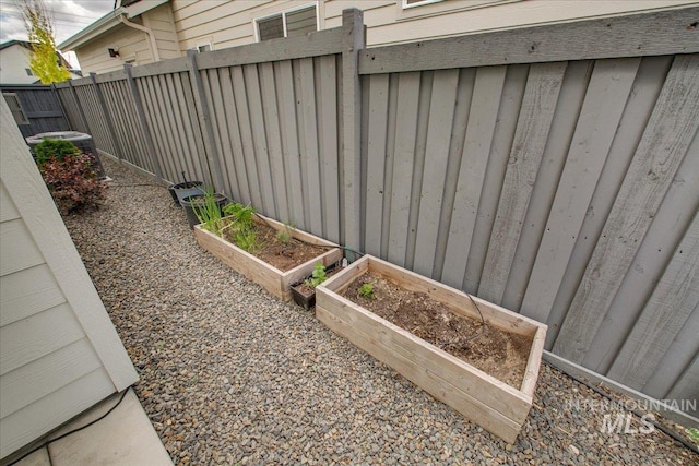 view of yard featuring a garden, fence, and cooling unit