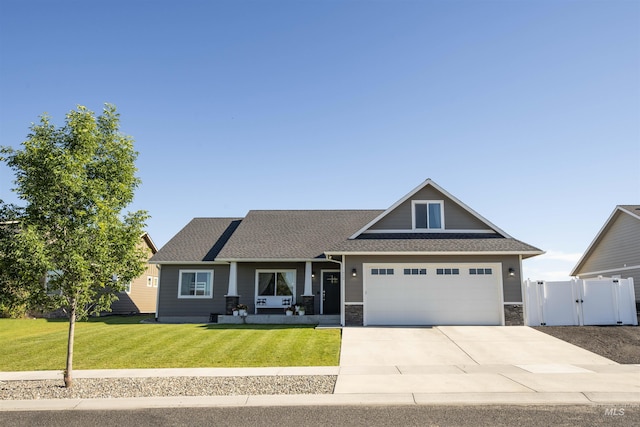 craftsman-style house featuring an attached garage, driveway, stone siding, a gate, and a front lawn