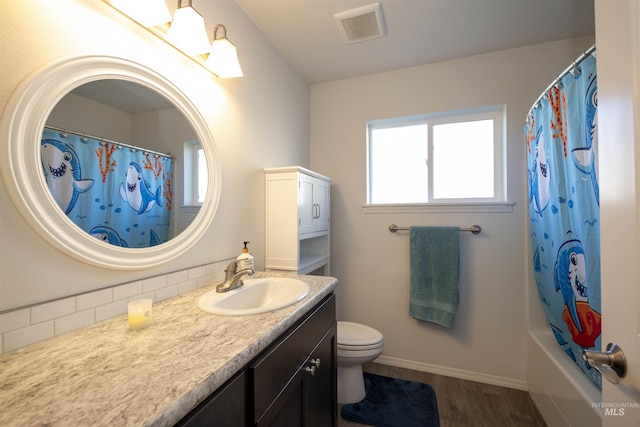 full bath featuring visible vents, toilet, vanity, wood finished floors, and baseboards