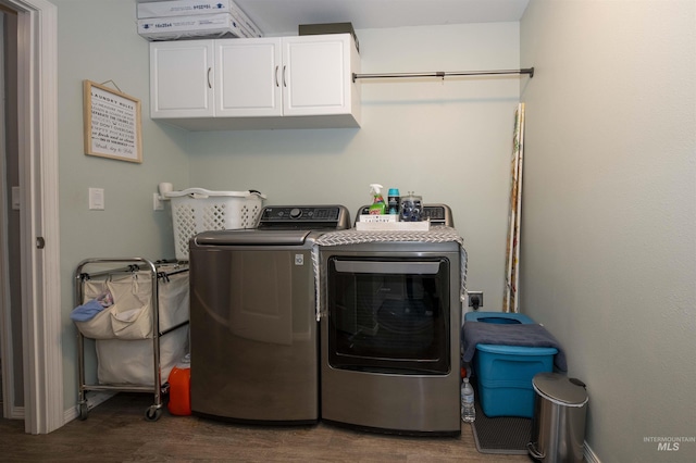 washroom with baseboards, dark wood finished floors, cabinet space, and washer and dryer