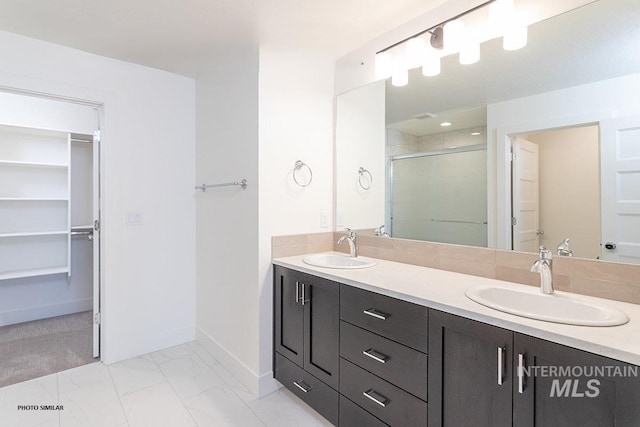 1327 N Webb Way, Meridian, ID 83642 - full bathroom featuring a walk in closet, a stall shower, double vanity, baseboards, and marble finish flooring