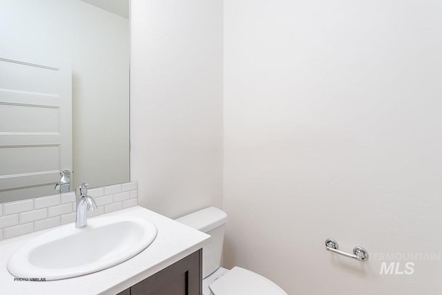 1327 N Webb Way, Meridian, ID 83642 - half bathroom featuring decorative backsplash, vanity, and toilet