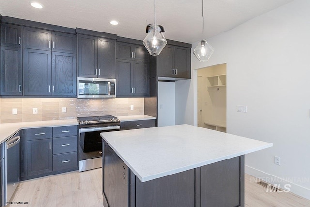 1327 N Webb Way, Meridian, ID 83642 - kitchen with stainless steel appliances, light wood-style floors, tasteful backsplash, light countertops, and a kitchen island