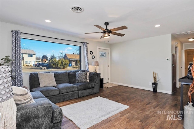 living room with dark wood-type flooring and ceiling fan