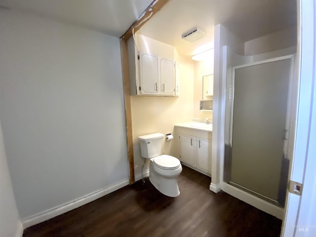 bathroom featuring hardwood / wood-style flooring, toilet, an enclosed shower, and vanity