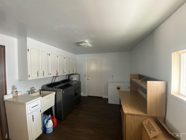 kitchen with washer and clothes dryer, white cabinets, dark hardwood / wood-style floors, and sink