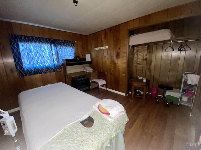 bedroom featuring dark hardwood / wood-style floors and wooden walls