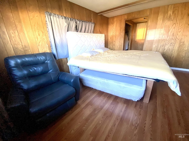 bedroom with wooden walls and hardwood / wood-style floors