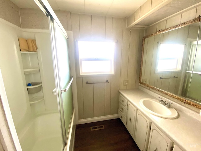 bathroom with wood walls, hardwood / wood-style floors, and vanity