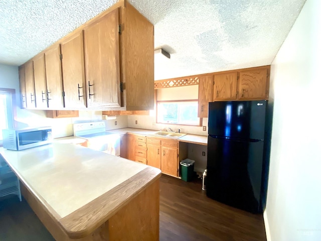 kitchen with sink, white electric range oven, dark hardwood / wood-style floors, kitchen peninsula, and black refrigerator