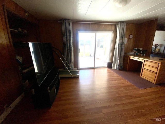 kitchen featuring wood walls, dark wood-type flooring, and built in desk