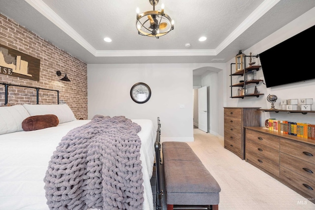 bedroom featuring a tray ceiling, carpet, brick wall, and a textured ceiling